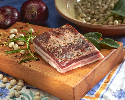 pancetta on a cutting board with sage and red onion