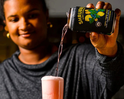 lemon shrubbly being poured into a tall glass