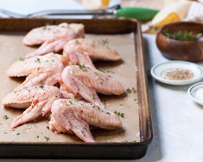 GMO-free chicken wings rubbed with herbs salt on tray