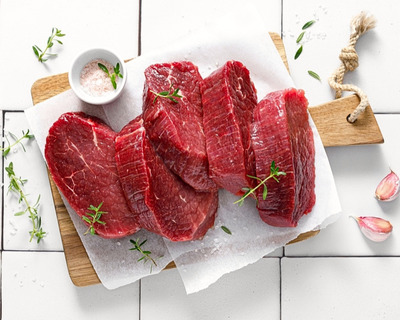 beef tenderloin steaks on a cutting board with garlic